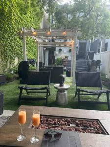 two glasses of orange juice on a table on a patio at A Dedicated Space To Unwind in Brooklyn