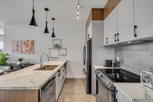 a kitchen with white cabinets and stainless steel appliances at Initial / Spritz / Downtown Qc +STAT in Quebec City