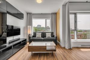 a living room with a couch and a tv at Initial / Spritz / Downtown Qc +STAT in Quebec City +40 photos