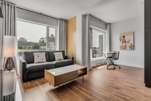 a living room with a couch and large windows at Initial / Spritz / Downtown Qc +STAT in Quebec City