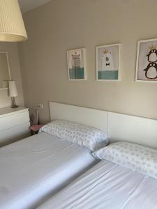 - une chambre avec 2 lits et des photos sur le mur dans l'établissement Casa con jardín a 200 mts de la playa, à San Vicente do Mar
