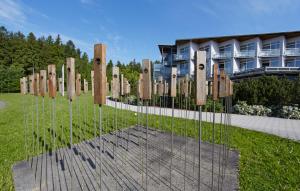 a group of wooden poles in a field with a building at Green Night in Falkenstein