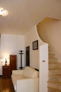 a living room with a white couch and stairs at Roma a un passo e il mare in casa in Marina di Cerveteri