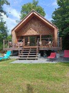 a large wooden cabin with colorful chairs and tables at Entre mare et chêne in Frasnes-lez-Anvaing