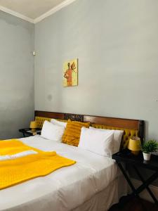 a bedroom with a bed with a yellow blanket on it at Palm Heaven B&B in East London