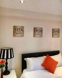 a bedroom with a bed and three signs on the wall at One Bedroom Flat in Central London in London