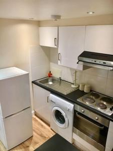a kitchen with a sink and a washing machine at One Bedroom Flat in Central London in London