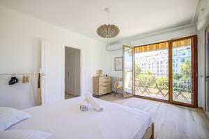 1 dormitorio con cama blanca y ventana grande en Sublime apartment with Parking - 2BR6p - Martinez Terrace en Cannes