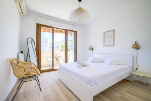 1 dormitorio blanco con 1 cama y 1 silla en Sublime apartment with Parking - 2BR6p - Martinez Terrace en Cannes