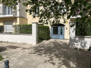 ein Haus mit einer blauen Tür und einem Gebäude in der Unterkunft Appartement 4 pièces proche Paris et Disneyland in Fontenay-sous-Bois