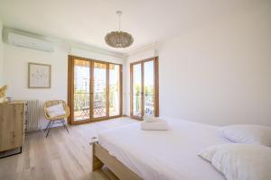 1 dormitorio blanco con 1 cama grande y 1 silla en Sublime apartment with Parking - 2BR6p - Martinez Terrace en Cannes
