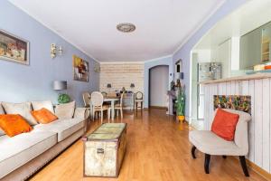 een woonkamer met een witte bank en een tafel bij Appart 4 pièces proche Site jeux Olympiques Disneyland et Paris in Fontenay-sous-Bois