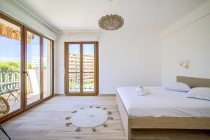 1 dormitorio con 1 cama y balcón en Sublime apartment with Parking - 2BR6p - Martinez Terrace, en Cannes