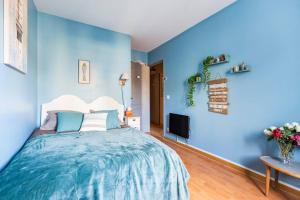 ein blaues Schlafzimmer mit einem Bett und einem TV in der Unterkunft Appartement 4 pièces proche Paris et Disneyland in Fontenay-sous-Bois