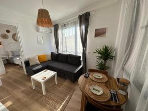 a living room with a black couch and a table at House of spring in Çeşme
