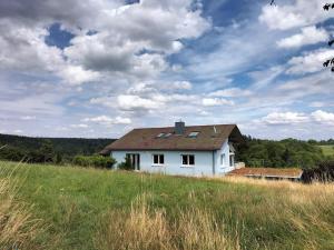 een wit huis in het midden van een veld bij Ausblick Maisenbach in Bad Liebenzell