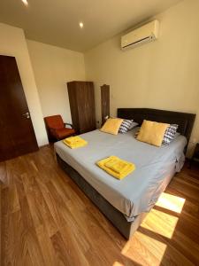 um quarto com uma cama com duas toalhas amarelas em Extremely comfy apt with spacious private terrace 10min walk to the beach & in Town em Lárnaca