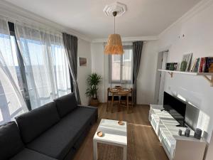 een woonkamer met een bank en een tv bij House of spring in Çeşme