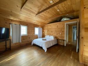 1 dormitorio con 1 cama en una cabaña de madera en Mountain Farmhouse (The Lorca, Catskills), en Shandaken