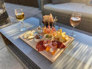 een dienblad met eten op een tafel met twee glazen wijn bij Mont Bouquet Lodge/Residence Hoteliere in Brouzet-lès-Alès