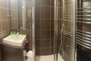 a bathroom with a shower with a sink and a toilet at LOUE STUDIO MEGEVE in Megève