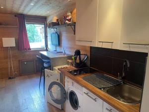 a kitchen with a sink and a washing machine at LOUE STUDIO MEGEVE in Megève +10 photos