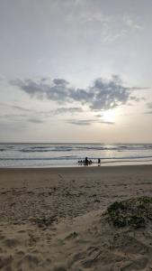 um grupo de pessoas andando a cavalo na praia em 5 Mile Beach Resort em Kumta