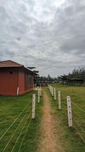 a fence in a field next to a building at 5 Mile Beach Resort in Kumta