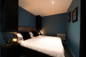 巴黎的住宿－Contrevents，卧室配有白色的床和蓝色的墙壁
