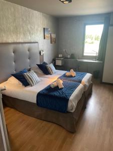 a bedroom with two beds with towels on them at Hotel Best Western La Mare Ô Poissons in Ouistreham