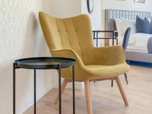 Phaedrus Living: Plateia Suite Grigio في نيقوسيا: كرسي اصفر وطاولة في الغرفة