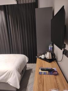 a bedroom with a bed and a desk with a television at Hostel Amasra in Bartın