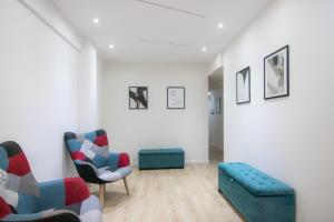 een woonkamer met 2 stoelen en een bank bij Phaedrus Living: Plateia Suite Grigio in Nicosia