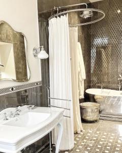 a bathroom with a sink and a shower and a tub at La Massonnière Gîtes et Jardins de prestige in Saint-Christophe-en-Champagne