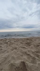 a sandy beach with the ocean in the background at Domki Sosnowa Przystań w Rozewiu - Jastrzębia Góra in Jastrzębia Góra