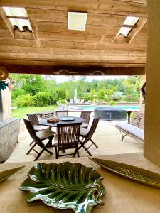 een patio met een tafel en stoelen en een zwembad bij Gite la Maison de la Pimpine Lignan de Bordeaux in Lignan-de-Bordeaux