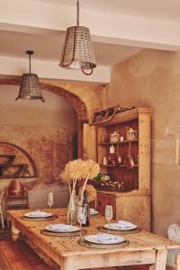 a dining room with a wooden table with plates and glasses at Lammas Retreat in Minchinhampton in Minchinhampton