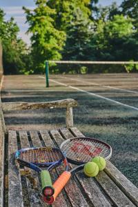 2 raquettes et balles de tennis sur un banc dans l'établissement Lammas Retreat in Minchinhampton, à Minchinhampton