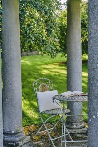 una silla y una mesa con un libro en el patio en Lammas Retreat in Minchinhampton en Minchinhampton