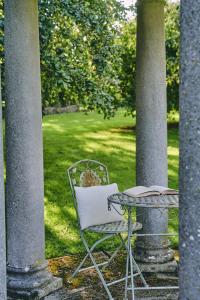 a chair and a table with a book on a patio at Lammas Retreat in Minchinhampton in Minchinhampton