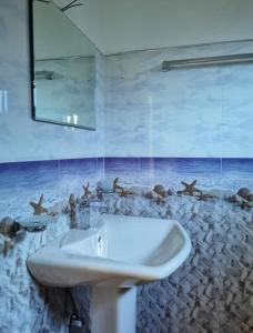 La salle de bains est pourvue d'un lavabo et d'une peinture murale représentant des personnes. dans l'établissement Ella Rock Glance, à Ella