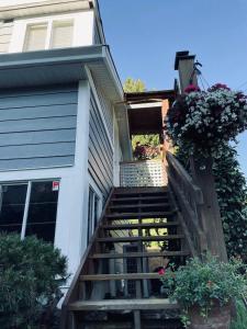 a staircase leading up to a house with flowers at Lantzville Treehouse in Lantzville