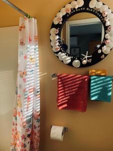 a bathroom with a mirror and towels on a rack at Lantzville Treehouse in Lantzville