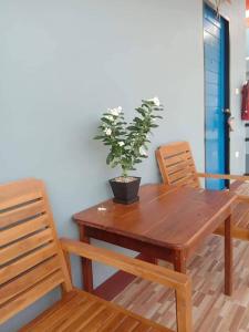 a wooden table with a potted plant on top of it at หม่อนเมือง รีสอร์ท in Chiang Rai