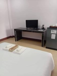 a desk with a computer on top of a bed at หม่อนเมือง รีสอร์ท in Chiang Rai
