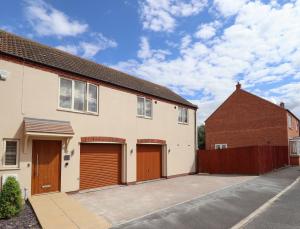 a house with two garage doors and a fence at 10 Mellor Way in Grimsby