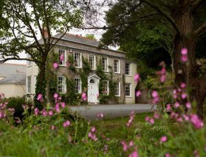 una casa con fiori rosa davanti di Rose in Vale Country House Hotel a St. Agnes 