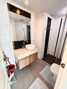 a bathroom with a sink and a toilet and a mirror at Blissful 1 Bed in Amazon Condo in Jomtien Beach