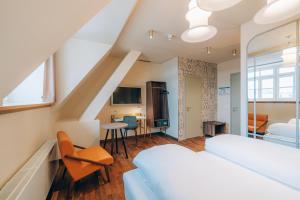 a bedroom with a bed and a living room at Hotel Amalia - Boutique Hotel in Landshut