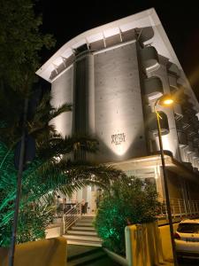 un bâtiment avec un palmier en face dans l'établissement Hotel Audi Frontemare, à Rimini